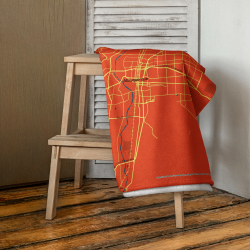 Custom orange Map Beach Towel featuring an Albuquerque map design with a teal location marker, shown draped over a chair.
