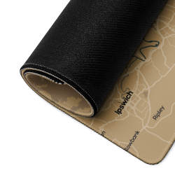 Close-up of a custom map gaming mouse pad showing the tan map design, stitched edge, and black textured backing.
