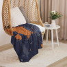 Custom Map Blanket featuring a dark blue and copper map design, draped over a wicker chair in a cozy living room setting.