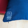 Close-up of the back side of a custom map pillow showing blue fabric texture and the MapStuff logo.