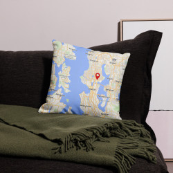Custom map pillow featuring a Seattle map design with a red location marker, styled on a dark couch with a green throw blanket.